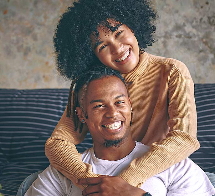 Image of an African-American couple relaxed and smiling after they were approved online by American First Finance.