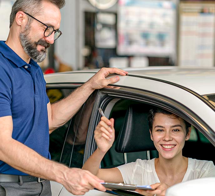 Female customer signing off on her auto repair after being approved for financing by American First Finance.
